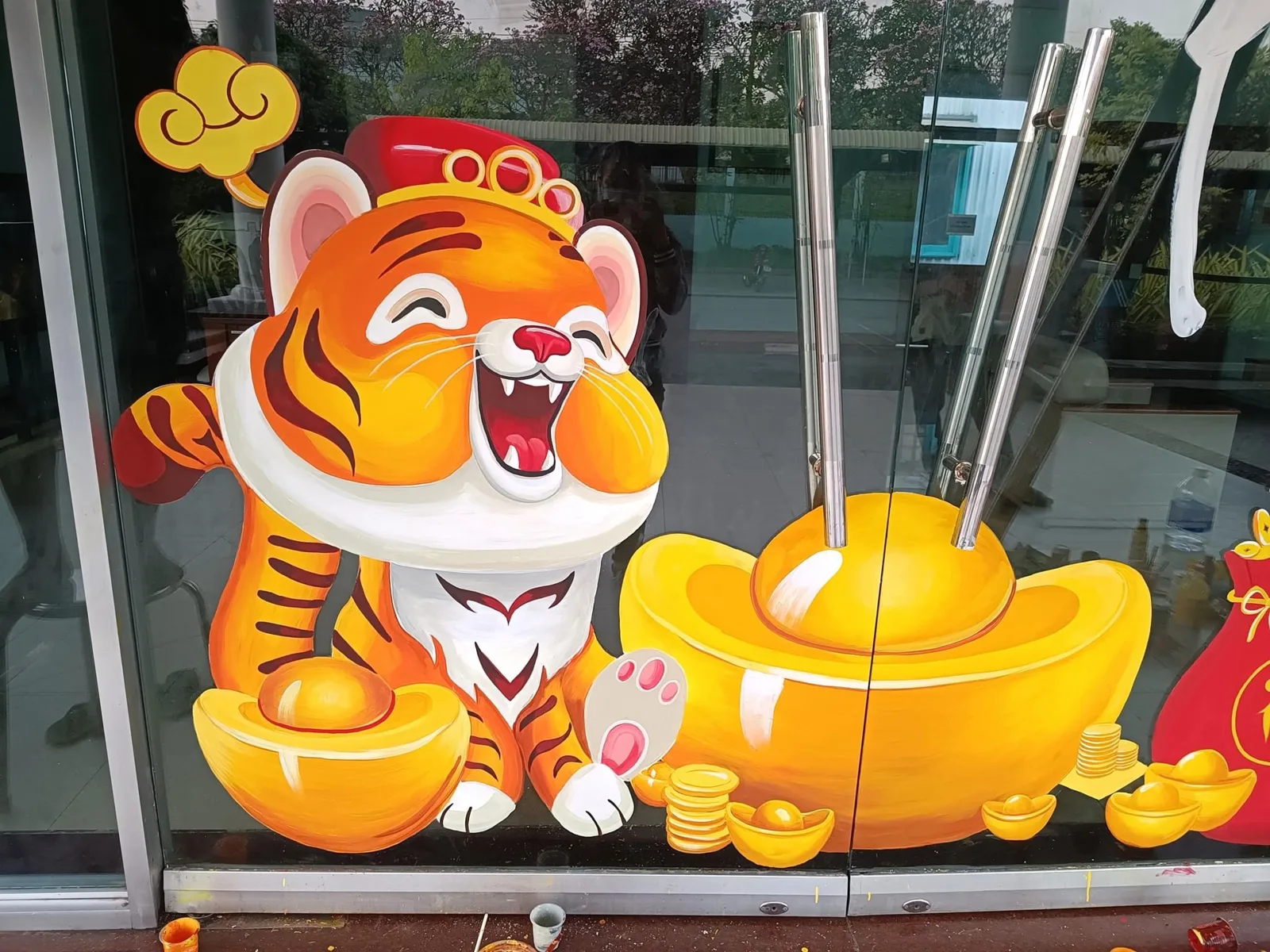 Vẽ tranh kính Tết linh vật hổ ôm thỏi vàng trên mặt tiền cửa hàng