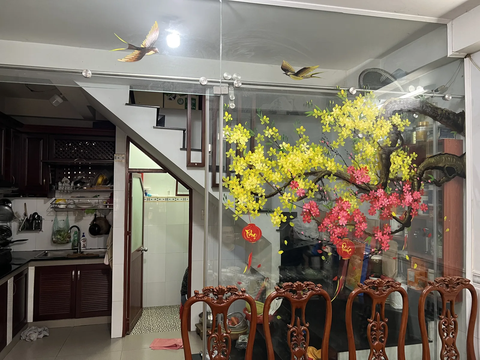 Vẽ tranh kính Tết mai vàng đào đỏ trên vách kính cầu thang nhà ở