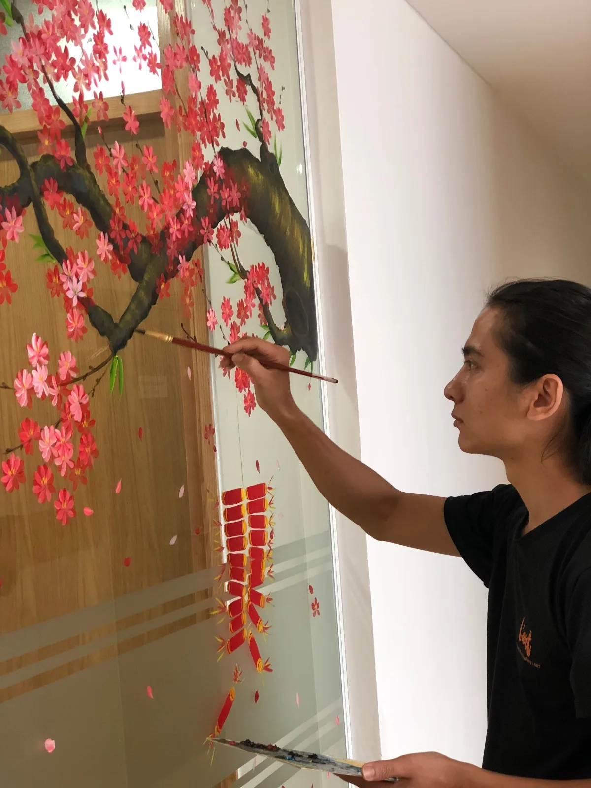 Vẽ tranh Tết lên cửa kính: cành hoa đào hồng và dây pháo đỏ