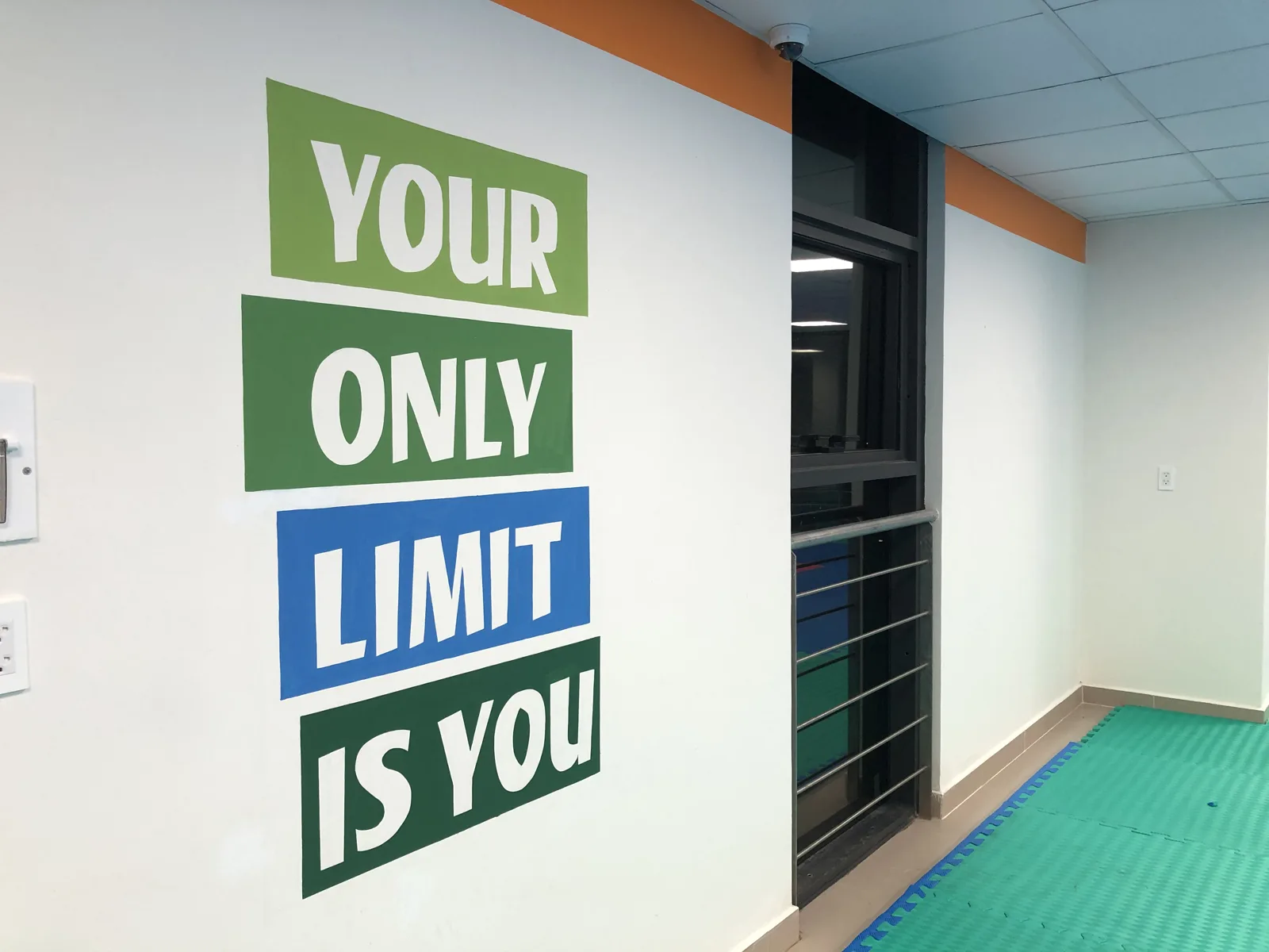 Vẽ chữ Your only limit is you trên tường phòng tập thể chất