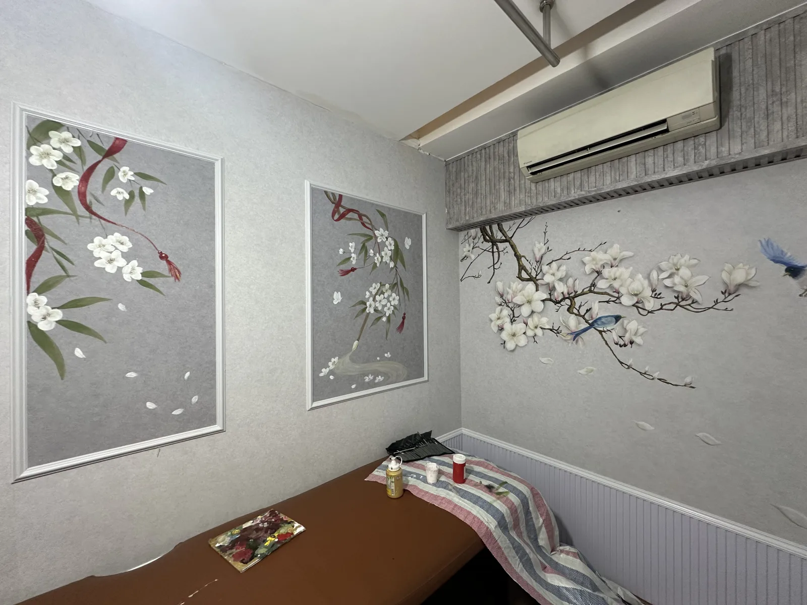 Vẽ tranh tường phòng spa nền xám với tranh hoa mai trắng và chim trong khung nẹp trắng